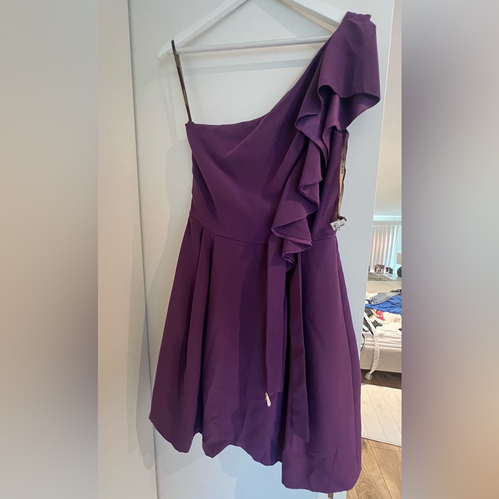 One shoulder Purple dress with a belt .
